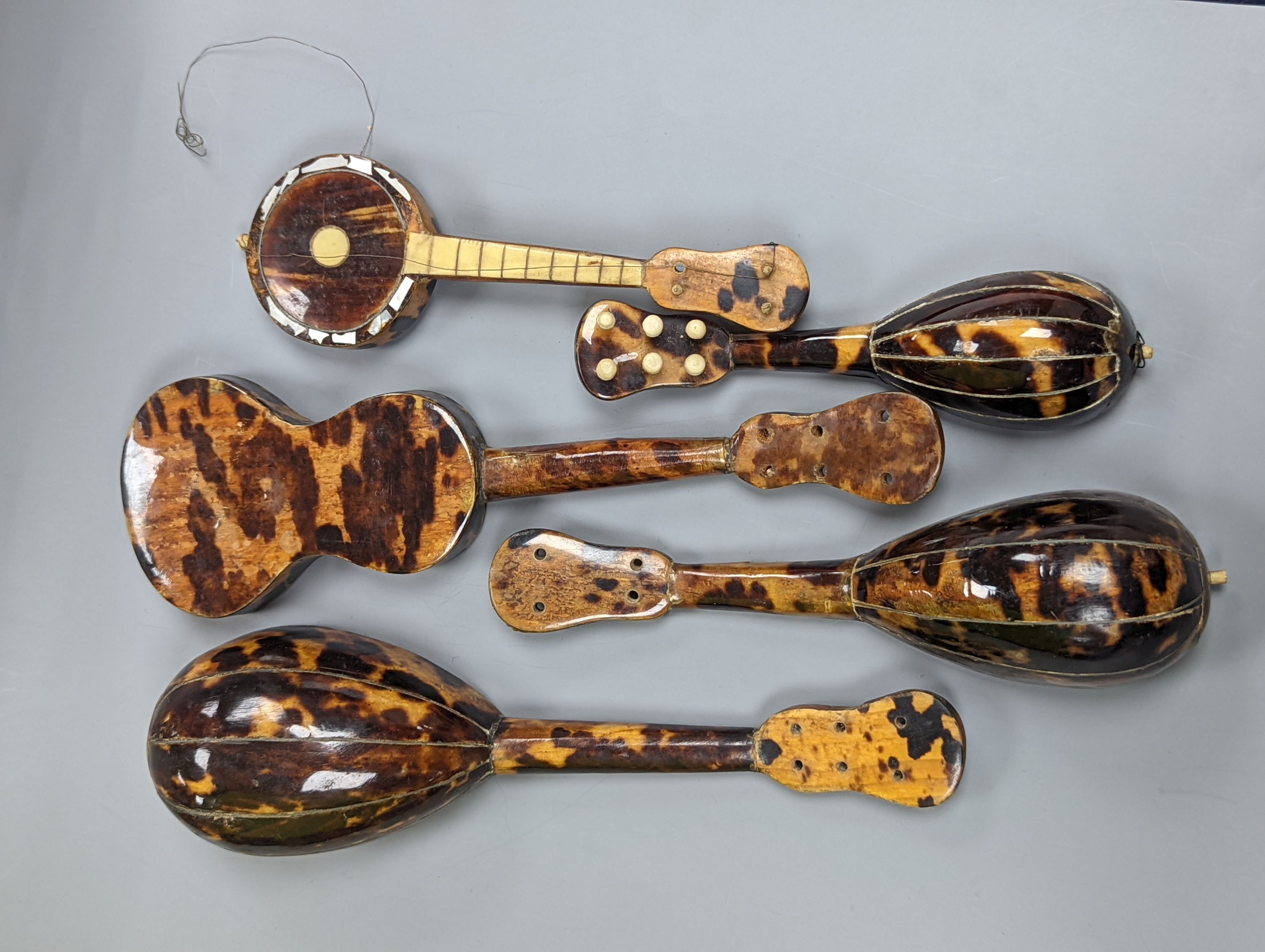 Five 19th century tortoiseshell miniature stringed instruments, longest 20cm.